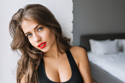 7closeup portrait ataddadng girl with long brunette hair modern apartment sexy t shirt true emotion red lips morning fashionable model relax